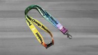 Rainbow coloured lanyard with Feminist, Peace Lover, Climate Change Warrior in black letters