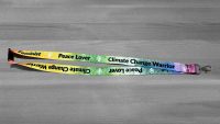 Rainbow coloured lanyard with Feminist, Peace Lover, Climate Change Warrior in black letters