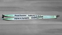 Green lanyard with Proud Feminist - Solidarity in Action in black letters